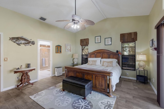 bedroom with vaulted ceiling, ceiling fan, ensuite bathroom, and light hardwood / wood-style floors