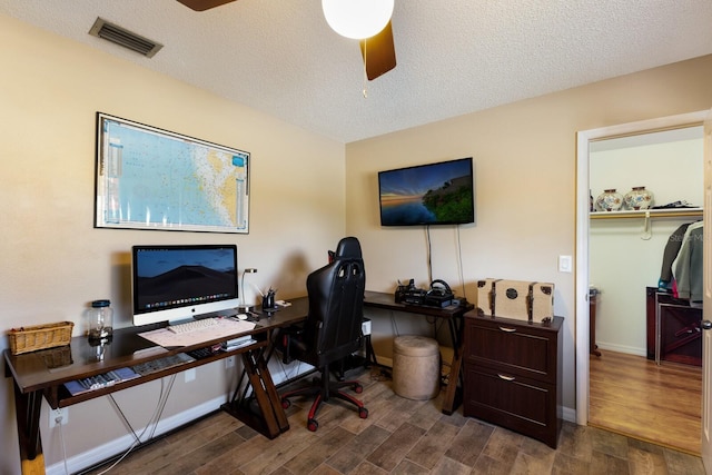 office space with ceiling fan, dark hardwood / wood-style flooring, and a textured ceiling