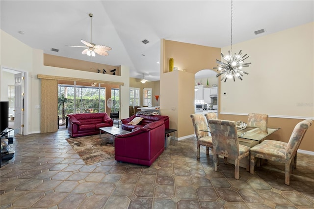 dining area featuring ceiling fan with notable chandelier and high vaulted ceiling