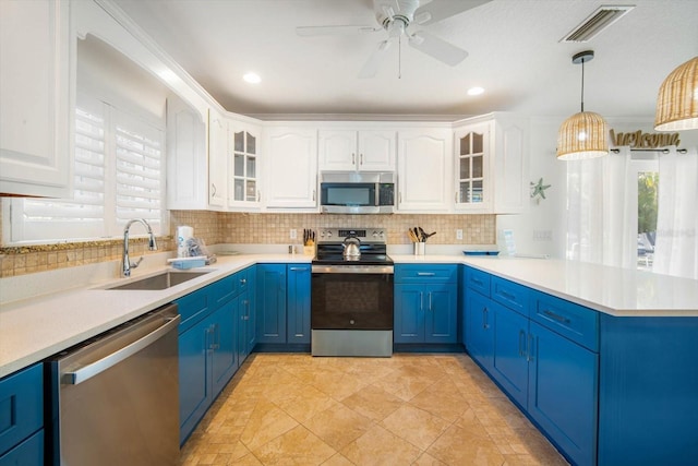 kitchen featuring pendant lighting, blue cabinets, white cabinetry, sink, and stainless steel appliances