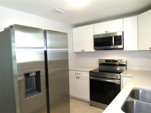 kitchen featuring white cabinetry, appliances with stainless steel finishes, and light tile patterned floors