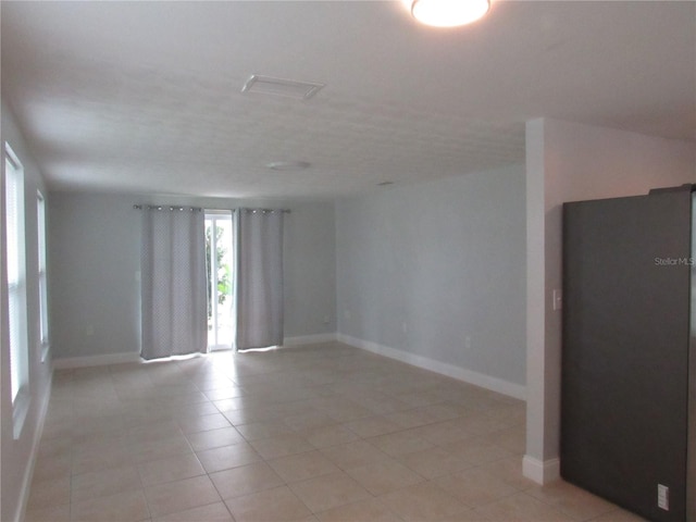 spare room featuring light tile patterned flooring