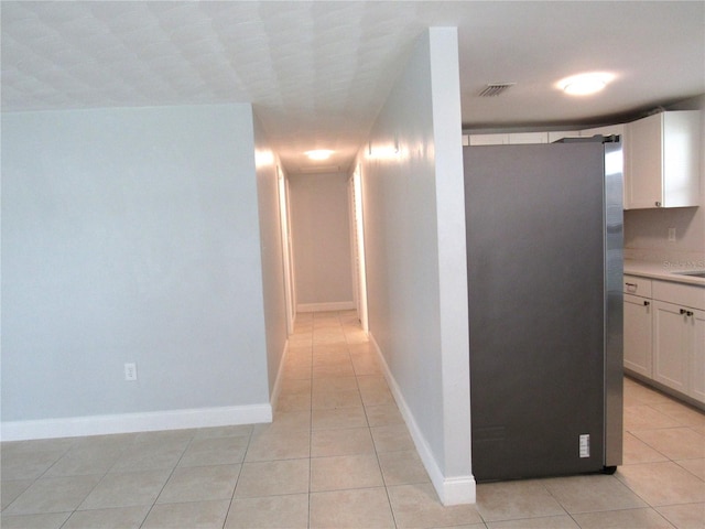 hall with light tile patterned floors