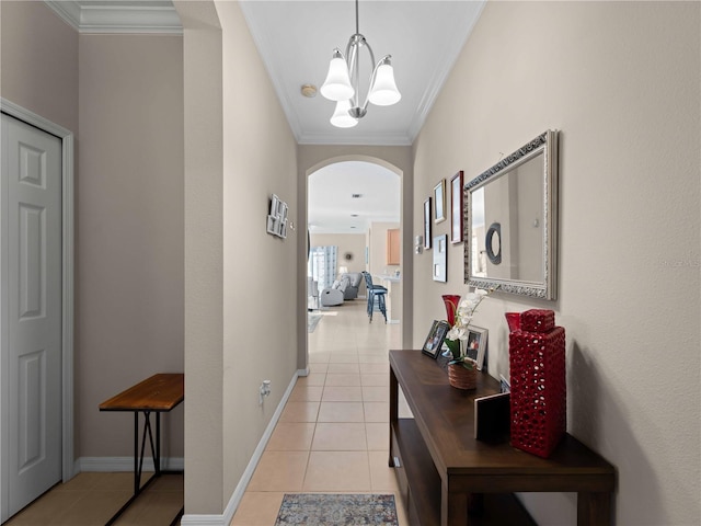 corridor featuring crown molding, a notable chandelier, and light tile patterned floors