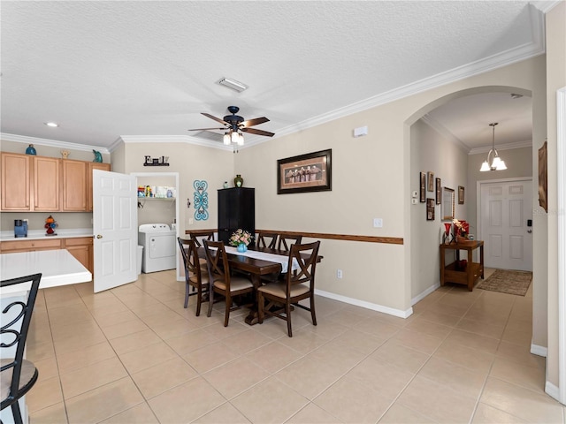 tiled dining space with crown molding, washer / dryer, ceiling fan with notable chandelier, and a textured ceiling