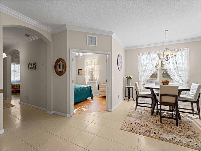 tiled dining area with plenty of natural light and ornamental molding