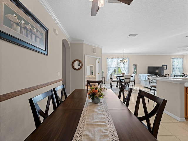 tiled dining space with crown molding, a textured ceiling, and ceiling fan