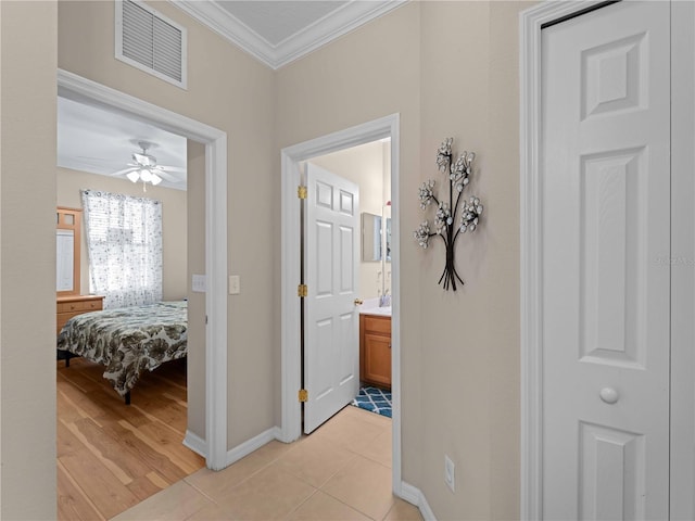 hall featuring ornamental molding and light tile patterned flooring