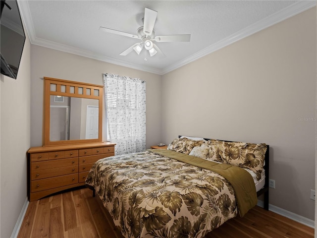 bedroom featuring hardwood / wood-style flooring, ceiling fan, and crown molding