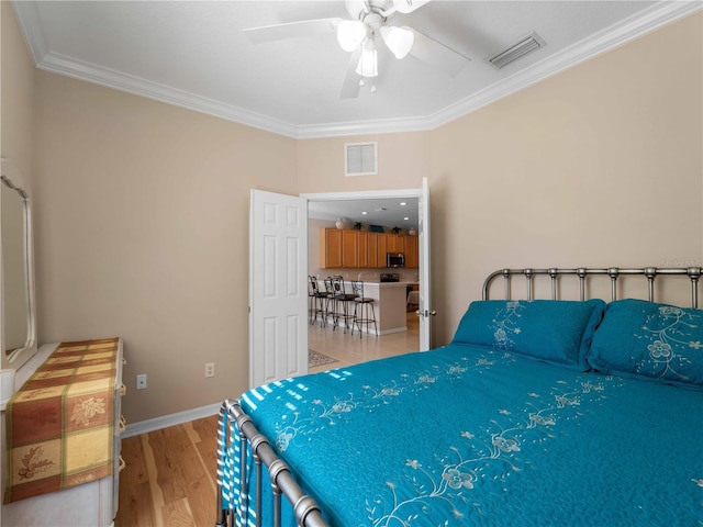 bedroom featuring ornamental molding, ceiling fan, and light wood-type flooring