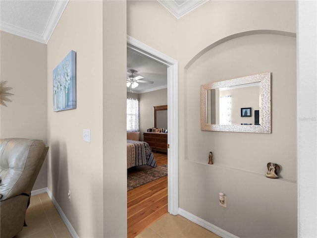 hallway with crown molding and light tile patterned flooring