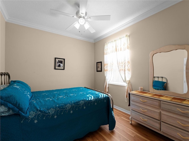 bedroom featuring crown molding, ceiling fan, and light wood-type flooring