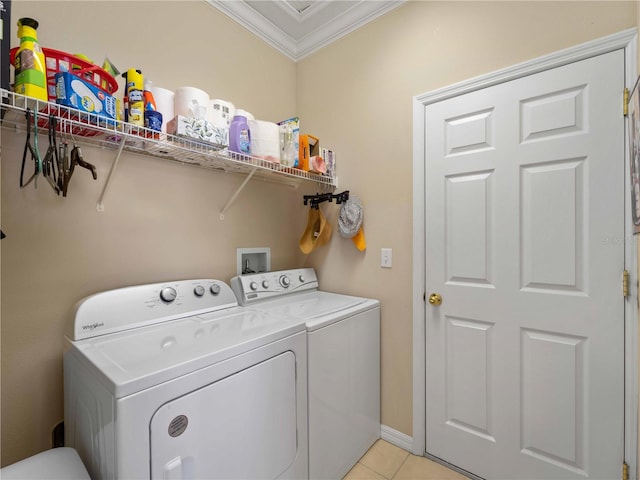 clothes washing area featuring ornamental molding, washing machine and dryer, and light tile patterned floors