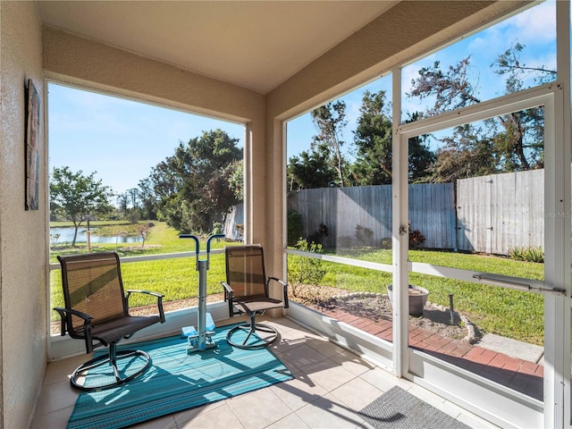 sunroom / solarium featuring a water view