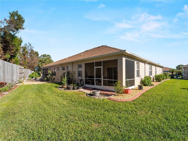 back of house featuring a lawn and a sunroom