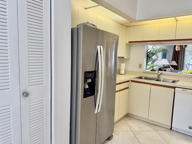 kitchen with sink, dishwasher, stainless steel fridge with ice dispenser, and light tile patterned floors