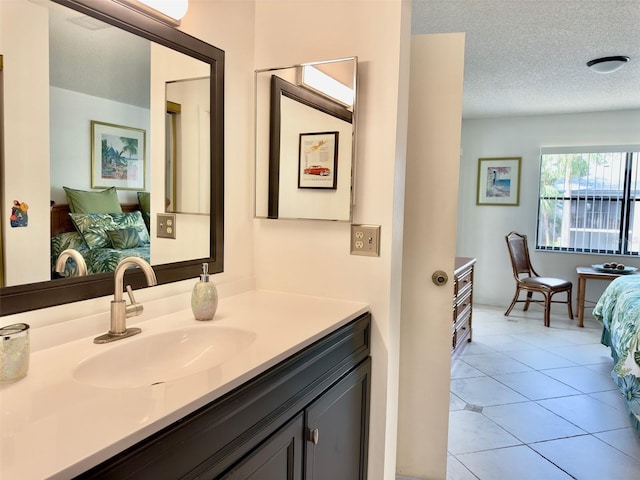 bathroom with tile patterned floors, a textured ceiling, and vanity