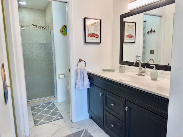 bathroom with vanity, tile patterned flooring, a shower with door, and toilet