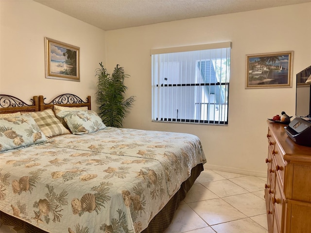 bedroom with light tile patterned flooring and a textured ceiling