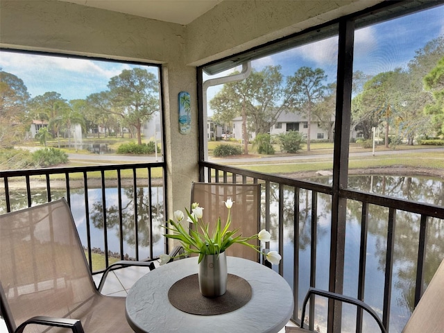 sunroom / solarium featuring a water view