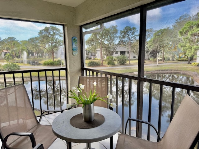 sunroom featuring a water view