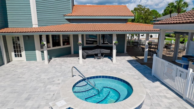 back of property with a patio area and a hot tub