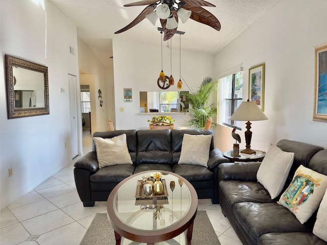 tiled living room with vaulted ceiling, ceiling fan, and a textured ceiling