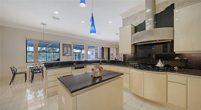 kitchen with ornamental molding, a kitchen island, pendant lighting, and wall chimney exhaust hood