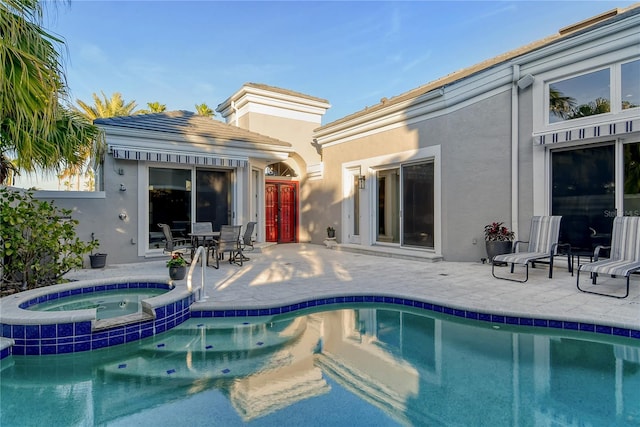 view of pool featuring an in ground hot tub and a patio area