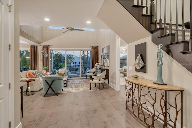 interior space featuring high vaulted ceiling, a skylight, and light hardwood / wood-style floors