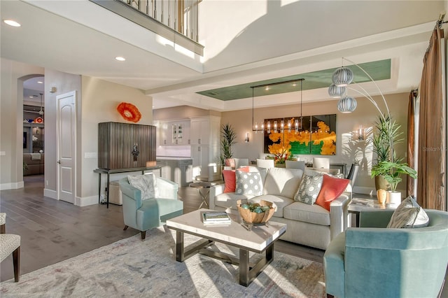 living room with wood-type flooring and a raised ceiling