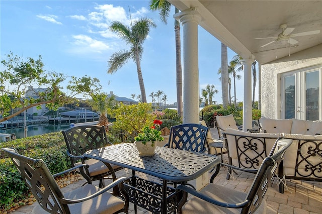 view of patio featuring a water view and ceiling fan