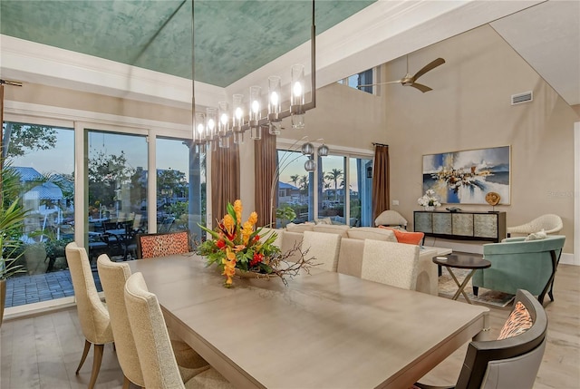 dining room with a high ceiling and light hardwood / wood-style flooring