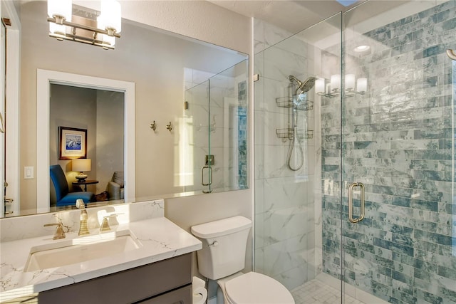 bathroom featuring vanity, an enclosed shower, and toilet