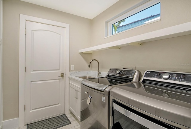 laundry area with separate washer and dryer, sink, and cabinets