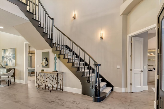 staircase featuring hardwood / wood-style floors and a high ceiling