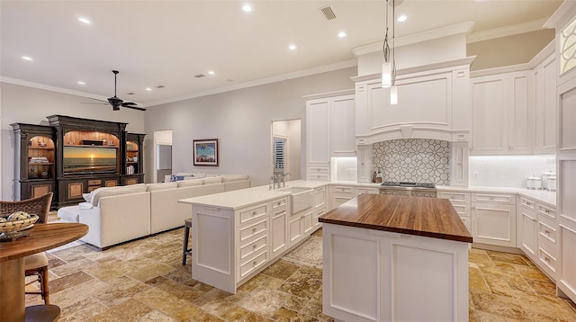 400 N Washington Dr, Sarasota, FL 34236 - kitchen featuring butcher block countertops, stone tile floors, recessed lighting, a peninsula, and a sink