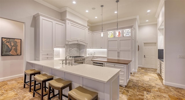 400 N Washington Dr, Sarasota, FL 34236 - kitchen with a sink, stone tile flooring, ornamental molding, baseboards, and a center island
