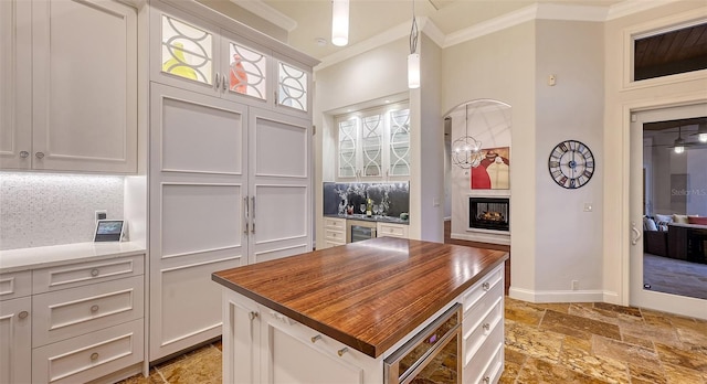 400 N Washington Dr, Sarasota, FL 34236 - kitchen featuring butcher block countertops, ornamental molding, stone tile flooring, decorative backsplash, and hanging light fixtures