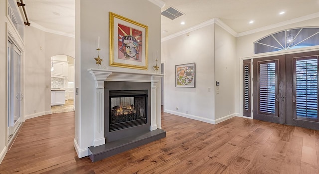 400 N Washington Dr, Sarasota, FL 34236 - foyer featuring french doors, wood finished floors, ornamental molding, a multi sided fireplace, and arched walkways
