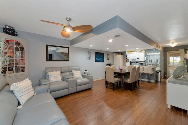 living room with ceiling fan and hardwood / wood-style floors