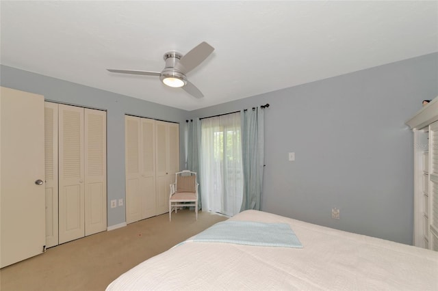 carpeted bedroom with two closets and ceiling fan