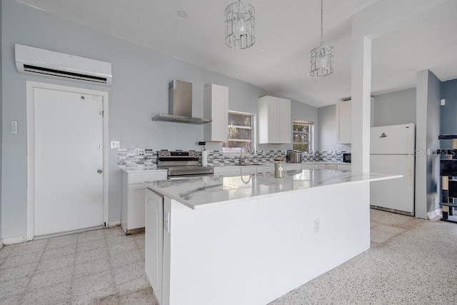 kitchen featuring wall chimney range hood, white cabinetry, a kitchen island, white refrigerator, and stainless steel electric range oven