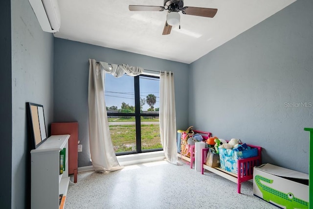 recreation room with ceiling fan and a wall unit AC