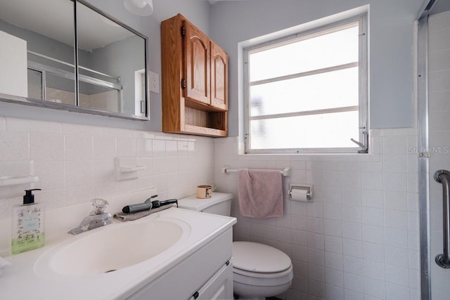 bathroom featuring an enclosed shower, vanity, tile walls, and toilet