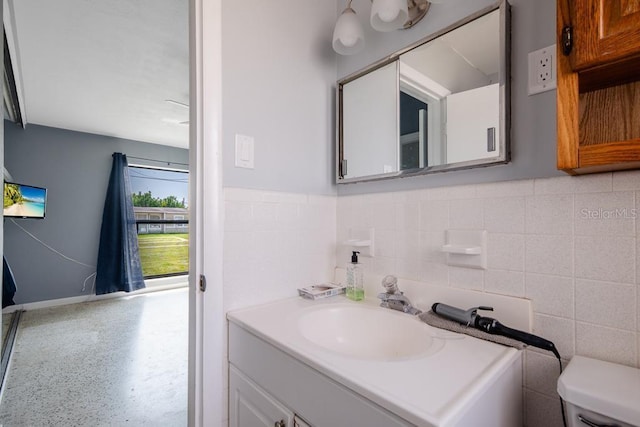 bathroom with vanity, tile walls, and toilet