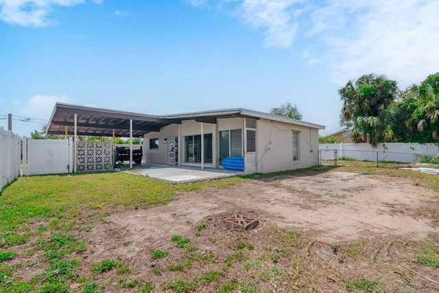 rear view of property featuring a yard and a patio