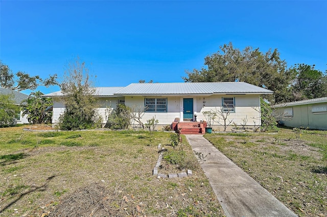 ranch-style home with a front lawn and metal roof