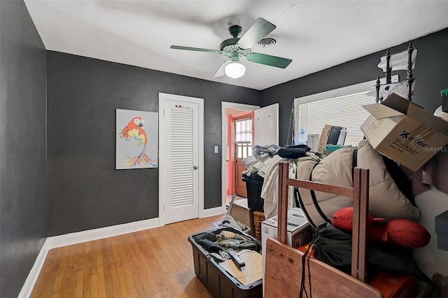 interior space featuring light wood finished floors, a ceiling fan, and baseboards