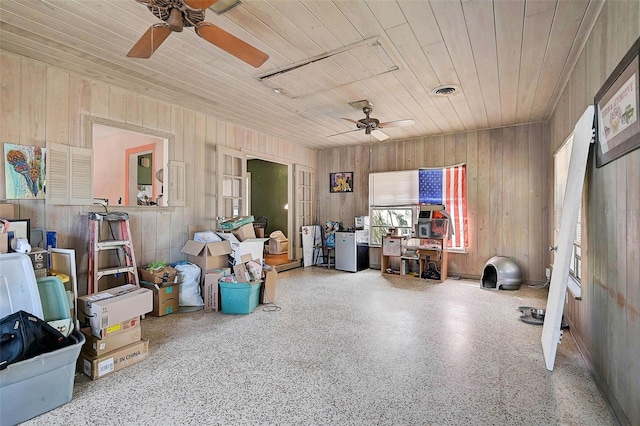 miscellaneous room with wood walls, wood ceiling, visible vents, and speckled floor